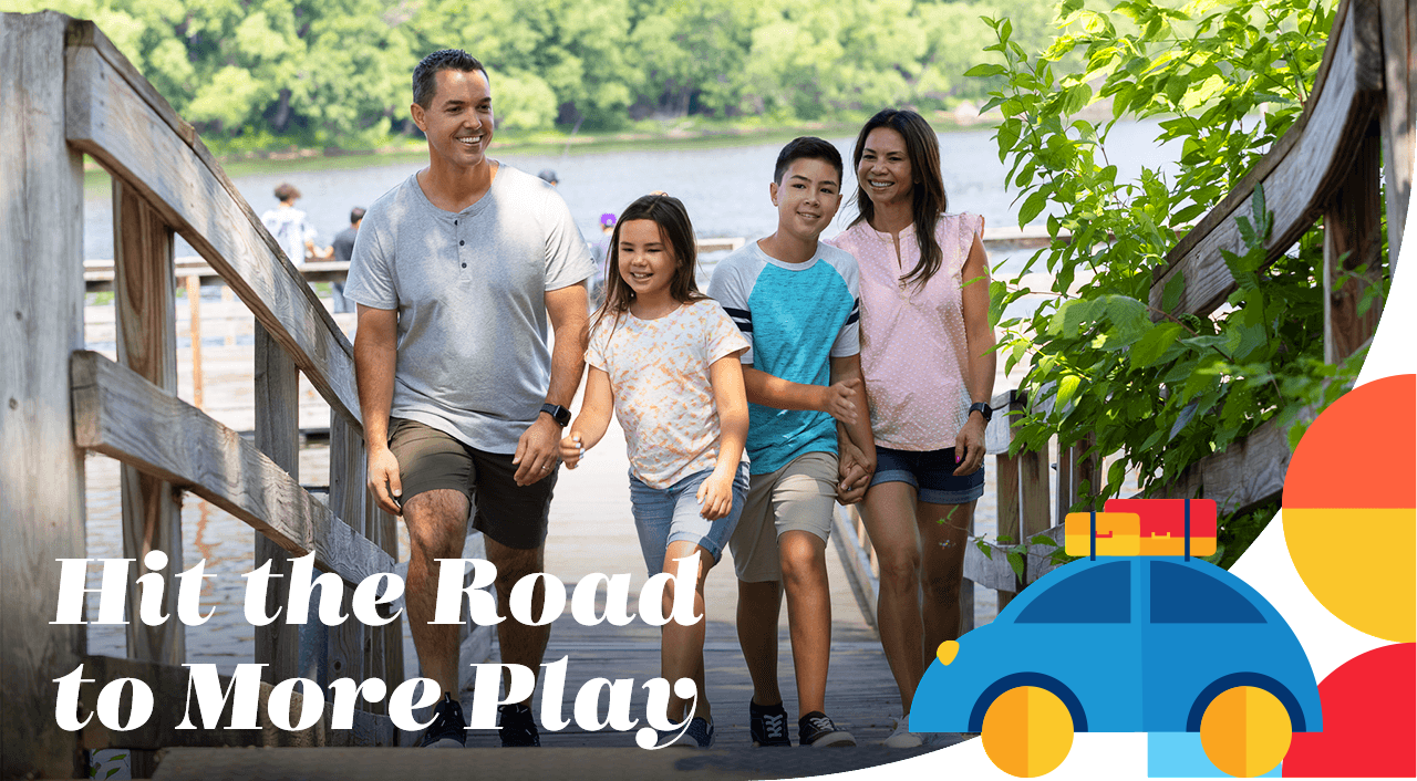 A family smiling while walking on a dock near the river. A headline reads: Hit the Road to More Play.
