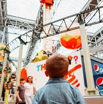 A boy looking up at the rides at the Mall of America.