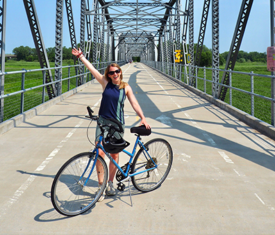 A woman holding her bike.