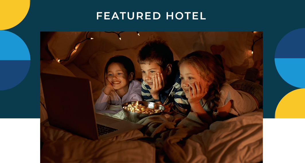 Featured Hotel - A group of kids watching a laptop screen in an in-room tent.